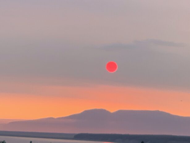 The setting sun, reddened by smoke from Siberia.
